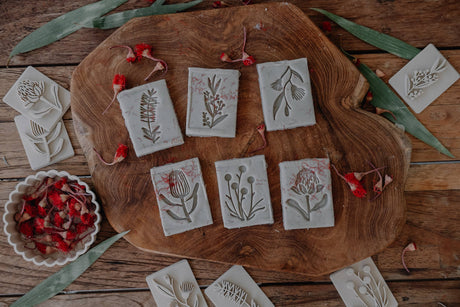 Decorative flower stamps with floral designs on a wooden board.