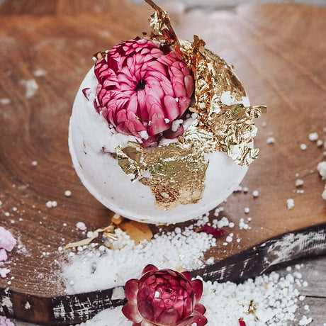 Childs botanical fizz flower and gold leaf on a wooden surface
