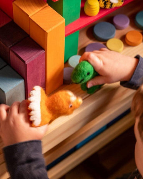 child playing with felt dinosaurs and blocks