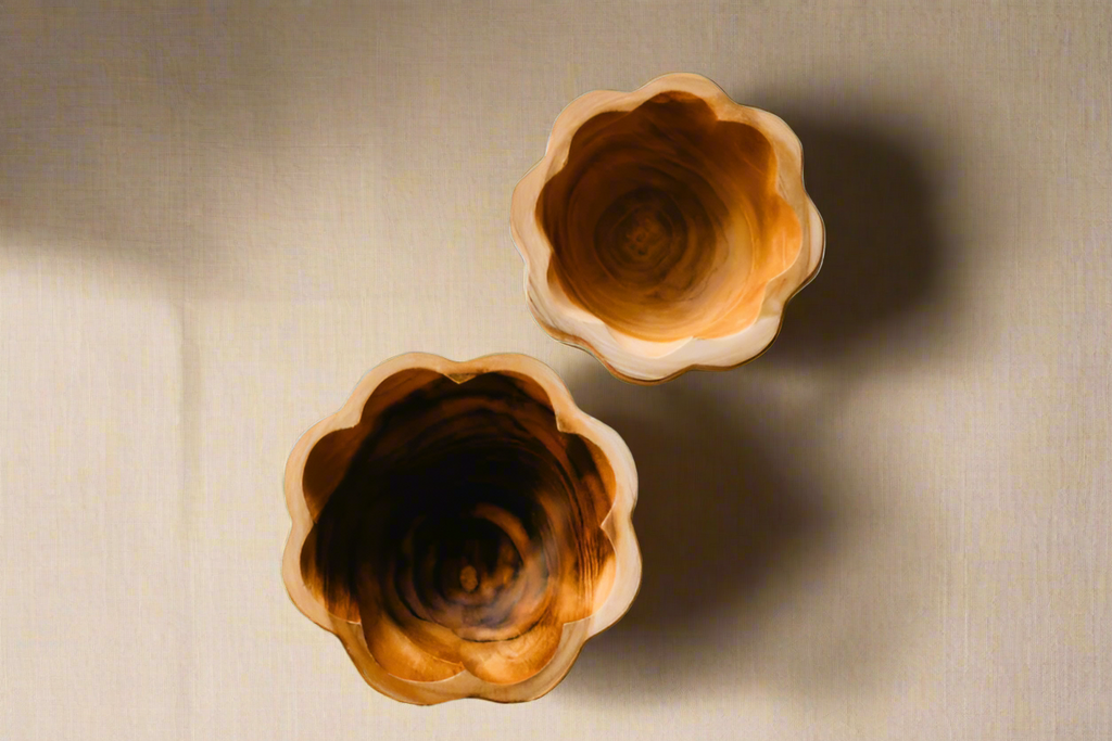 Two wooden bowls with a textured surface on a white background