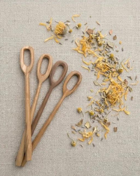 Wooden bubble wands with dried flowers on a textured fabric background