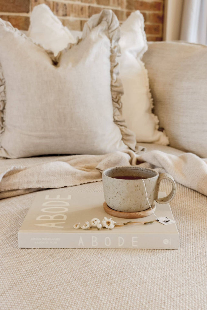 Ruffle cushion cover with decorative elements on a beige sofa
