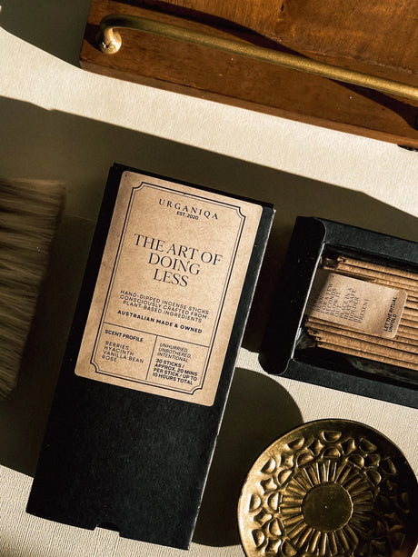 Product packaging with a label reading 'The Art of Doing Less' on a textured surface.