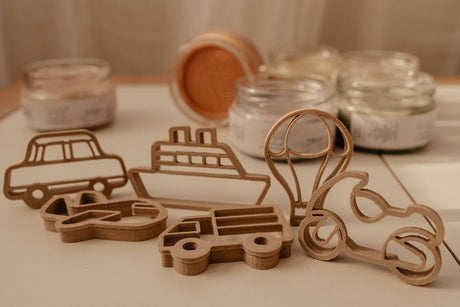 Wooden cutout shapes of vehicles on a neutral background