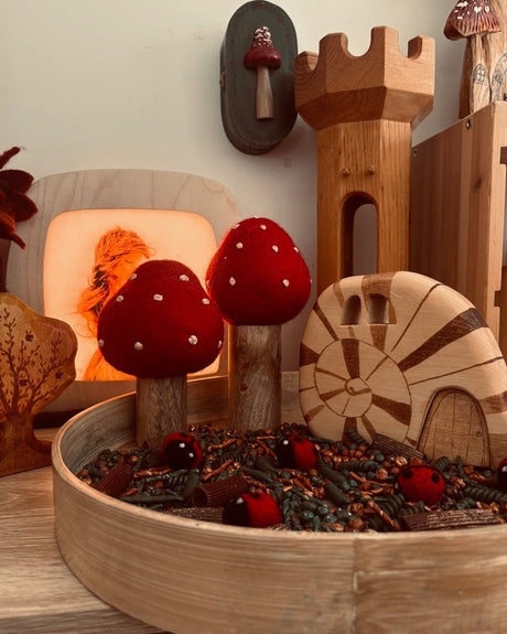Wooden decorative items including mushrooms and a castle on a wooden surface.
