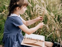 girl in nature with herbarium journal