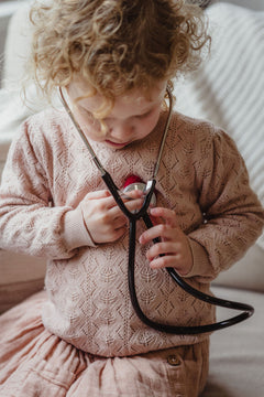 young girl playing with stethoscope