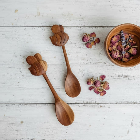 Two wooden spoons with floral decorations on a white surface