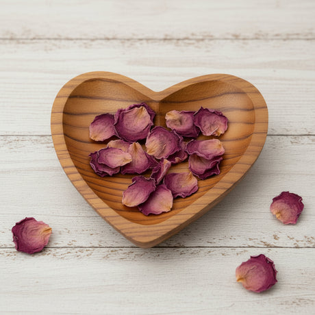 Wooden heart-shaped bowl on a light brown surface