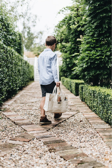 Boy carrying everyday cotton canvas tote bag filled with art and craft supplies