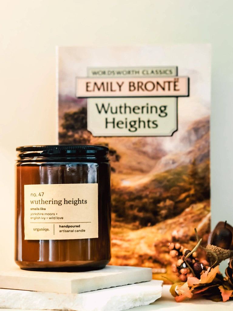 Candle labeled 'Wuthering Heights' by Emily Bronte with a book and decorative elements on a light background