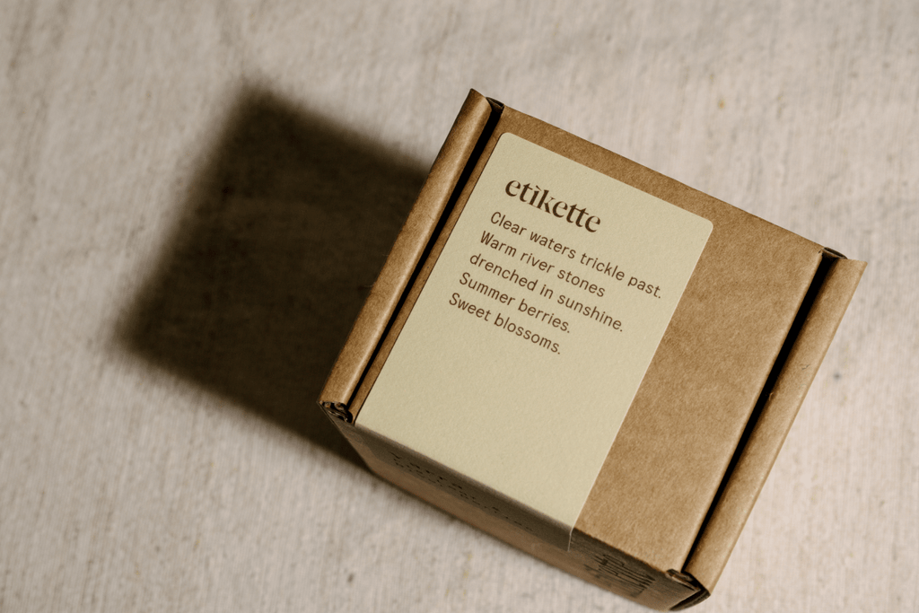Brown Yarrra candle box with a label on a beige surface