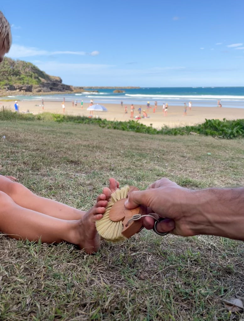 Child feet and Beach Brush Sand Remover